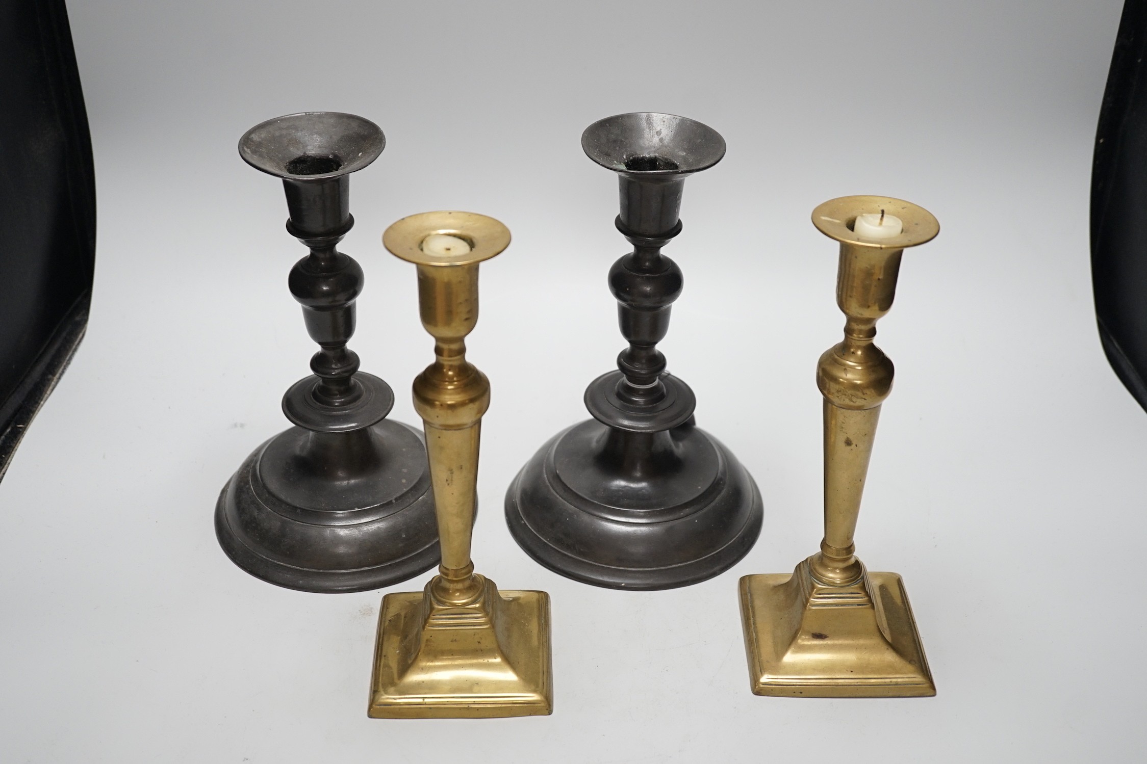 A pair of 18th century continental, possibly German, pewter candlesticks- 24cms high and a pair of late Georgian brass candlesticks